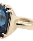 Gold ring with a blue gemstone on a white background