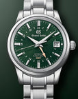 Grand Seiko watch with green dial and silver bracelet on a dark background