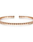 A rose gold beaded cuff bracelet with a closed clasp, showcasing a pattern of beads on a white background.