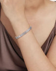 white gold bracelet on a person wearing a brown top