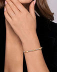 Gold and silver bracelet on a person's wrist with a neutral background
