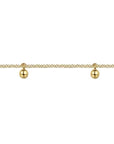 Gold bracelet with three spherical charms on a white background