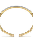 Gold beaded bracelet with a diamond-studded band on a white background side view