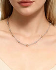 Necklace with small beads worn by a model on a neutral background