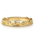 Gold ring with intricate design on a white background