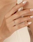 Close-up of a hand wearing a gold ring with a soft focus background
