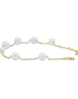 Gold chain bracelet with pearls on a white background