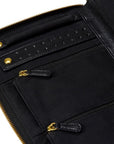 Close-up of a black leather and fabric zip-around jewelry organizer with gold-tone hardware, showing interior compartments, a textured strap, and zipper pulls on a white background.