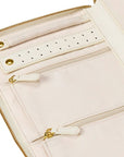 Close-up of a pale blush pink zip-around organizer or clutch with multiple interior zip compartments, a perforated detail strip, and gold-tone hardware.