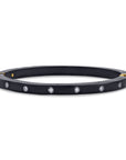 Black bracelet with gold accents and embedded stones on a white background