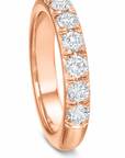 A rose gold ring featuring a row of round brilliant-cut diamonds set in a polished band, shown on a clean white background.