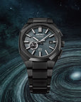 Black titanium Seiko Astron with blue textured dial on a space swirled background
