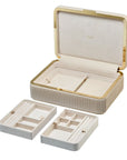 Beige jewelry box with gold accents opened with compartments removed on a white background