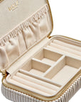 Beige jewelry case with gold zipper and interior compartments on a white background