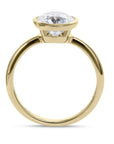Side shot of a yellow gold solitaire engagement ring with a bezel set brilliant round diamond from Clarity Diamonds