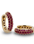 Gold hoop earrings with red gemstones on a white background