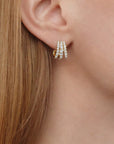 Close-up of an ear wearing a gold hoop earring with diamonds