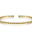 Gold beaded bracelet on a white background