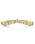A Gabriel & Co. Devotion curved anniversary band, showcasing a contoured line of 0.15 carats of round prong-set diamonds in high-polish 14k yellow gold, designed to sit flush against an engagement ring.