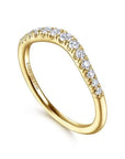 angled view of curved anniversary band, showcasing a contoured line of round brilliant-cut diamonds set in high-polish 14k yellow gold, sculpted to fit flush against an engagement ring.