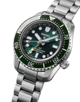 close up of Seiko watch with green dial and silver metal bracelet angled on a white background