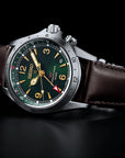 Seiko watch with a dark green face and brown leather strap on a black background