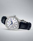 Seiko watch with black leather strap laying on its side on a gray background
