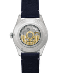 back of Seiko watch with blue strap and visible mechanical components on a white background