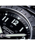 Close-up of a Seiko watch with a black dial and metallic case.