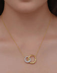 Gold necklace with a double-circle diamond pendant on a model