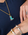 blurred bracelets on a wrist and blue necklace in background