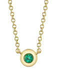 A front view of the Shy Creation Bailey Emerald Bezel Necklace (Style SC55026484) showcasing a dainty round natural green emerald in a smooth 14k yellow gold bezel pendant, suspended from a fine matching gold cable chain on a crisp white background.