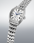 angled close up view of silver watch with white dial and blue hands on a gradient grey background