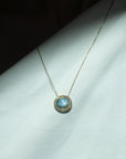 Necklace with a blue gemstone pendant on a light gray surface