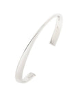 A Royal Chain sterling silver sculpted cuff bangle (Reference AGB10242) showcasing an open-back design with an irregular, fluid wavy silhouette finished in a high-polish rhodium plating against a crisp white background.