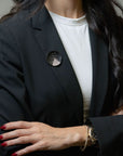 Model wearing Logan James sculptural black steel and white gold 1.05ctw diamond brooch on blazer