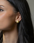 Model wearing Logan James Scatter 18K yellow gold oval diamond stud earring, lifestyle close-up