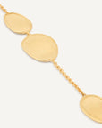 A up close view of the gold chain bracelet featuring three large, flat oval disc charms connected by delicate gold links, shown against a clean off-white background.