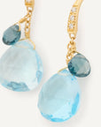 Gold earrings with blue teardrop-shaped gemstones on a white background