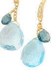 Gold earrings with blue teardrop-shaped gemstones on a white background