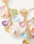 Multicolored gemstone and pearl earrings on a white background