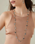 Woman wearing a long necklace with a neutral background
