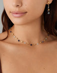 Woman wearing a delicate necklace with small beads on a neutral background