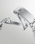 A close-up studio shot of a polished stainless steel watch band clasp and adjacent links on a light gray gradient background.