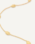 Gold necklace with round pendants on a blurred background