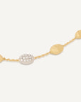 Gold necklace with round and oval beads on a white background