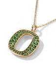 A gold initial pendant necklace featuring a large letter 'O' paved with small green gemstones, suspended from a delicate gold chain on a white background.