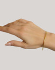 Lika Behar Yellow Gold 2mm Thin Bangle Bracelet modeled