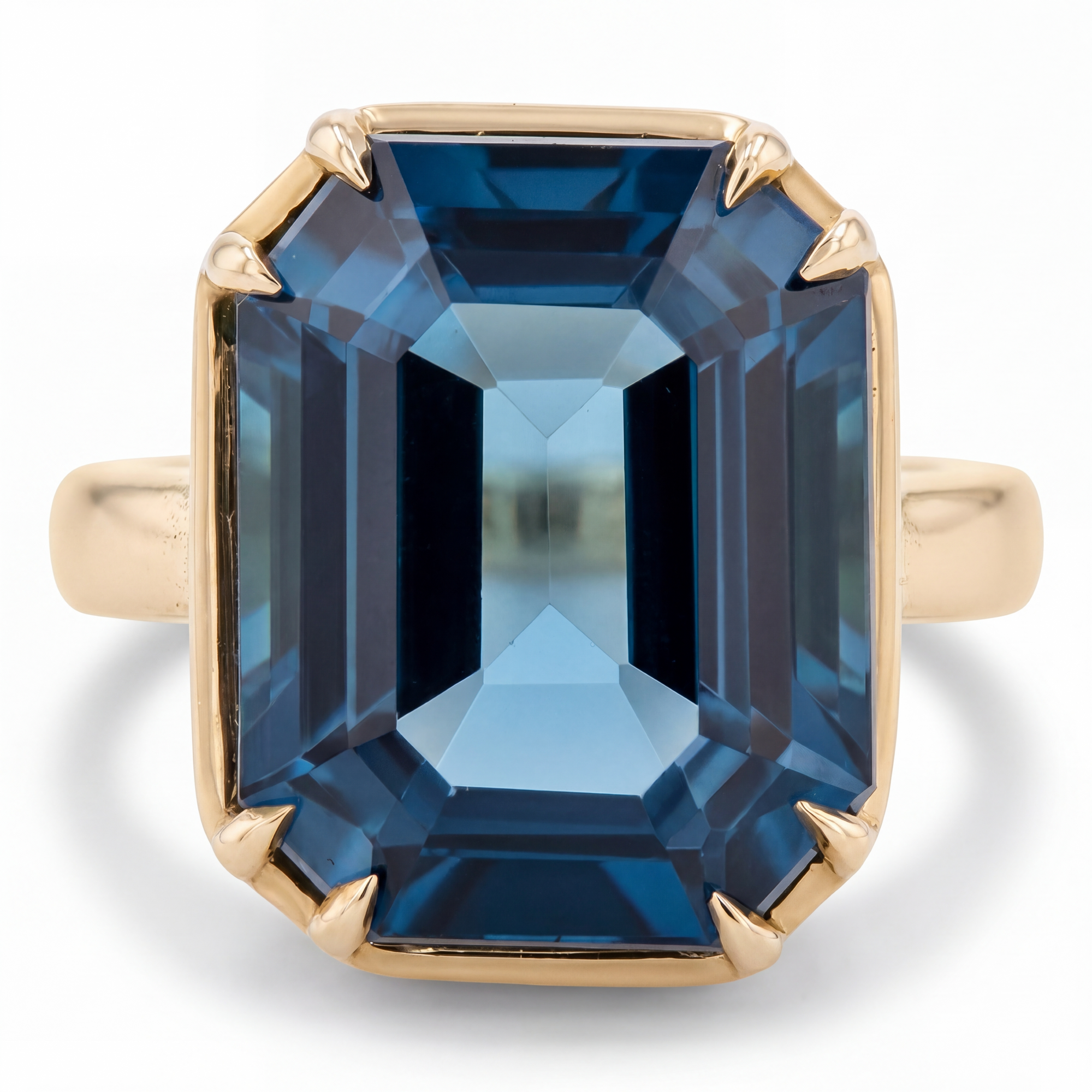 Gold ring with a large blue gemstone on a white background