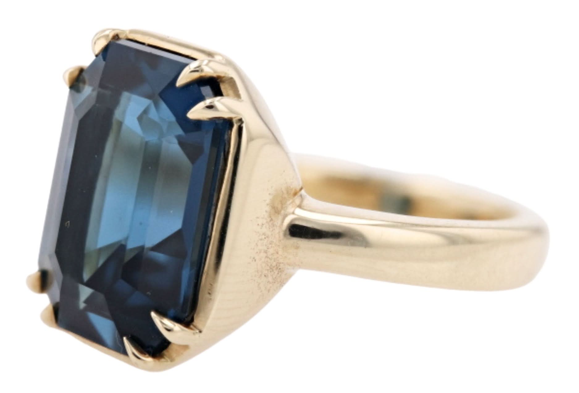 Gold ring with a blue gemstone on a white background